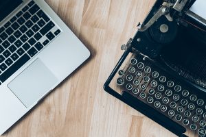 3 Reasons to Hire a Professional Cleaning Company blog - laptop next to typewriter